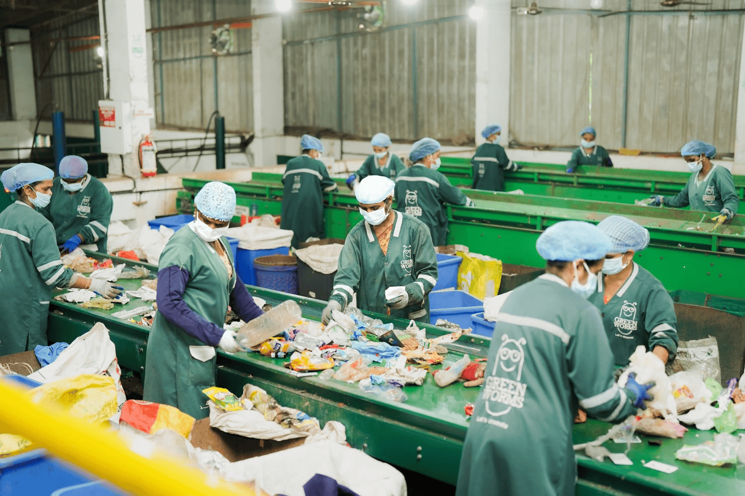 Workers sorting plastic waste on a conveyor belt